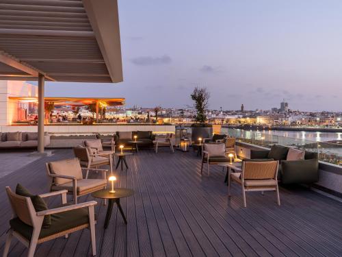 a rooftop patio with furniture and a view of a city at Fairmont La Marina Rabat Sale Hotel in Rabat