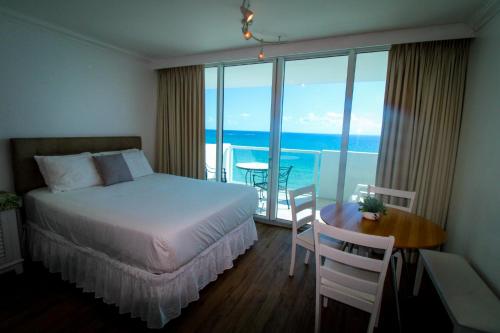 een slaapkamer met een bed en een tafel met uitzicht op de oceaan bij Balcony studio with Ocean View in Miami Beach