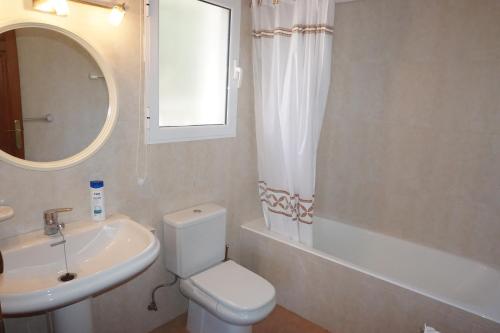 a bathroom with a toilet and a sink and a mirror at Los Tulipanes in Pego