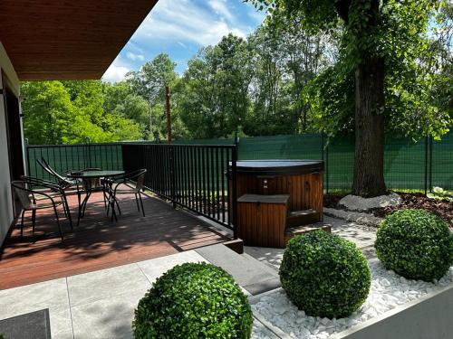 a patio with a table and chairs and a tree at WRZOS resort & wellness **** DOMKI CAŁOROCZNE in Węgierska Górka