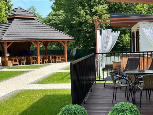 a deck with a gazebo and a table and chairs at WRZOS resort & wellness **** DOMKI CAŁOROCZNE in Węgierska Górka