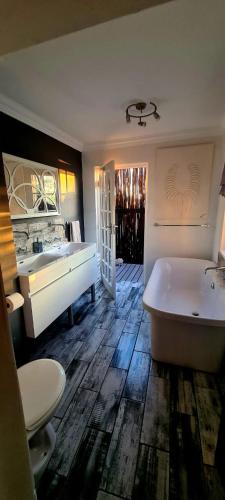 a large bathroom with a tub and a sink at Waterfront Cottage Stand 122 in Oranjeville