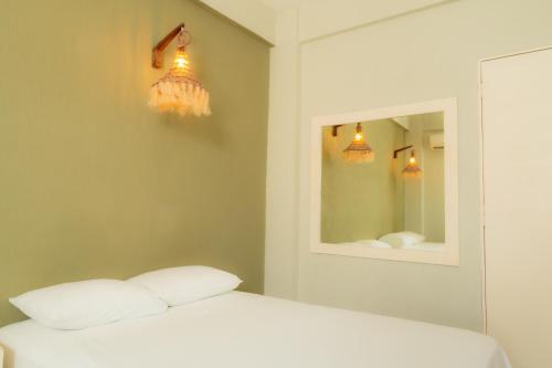 a white bed with two pillows and two mirrors at Caribe Princess in Chetumal