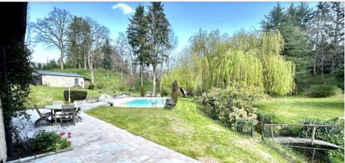 einen Hinterhof mit Pool und Garten in der Unterkunft La Petite Vernoelle in Prémilhat