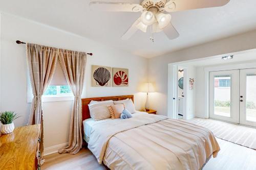 a bedroom with a bed and a ceiling fan at Ocean Beach Bungalow in Ormond Beach