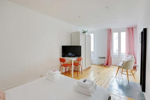 un salon blanc avec une table et des chaises dans l'établissement Charming appartement - 1BD-4P - Batignolles, à Paris
