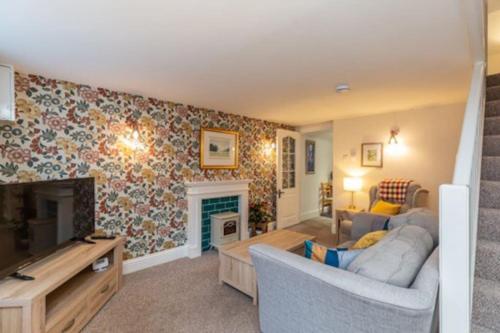 a living room with a couch and a fireplace at Cosy Cottage - Apple Pie Luxury Escapes in Bere Alston