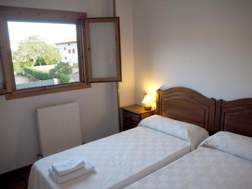 a bedroom with two beds and a window with a mirror at Posada de Ollo in Ollo