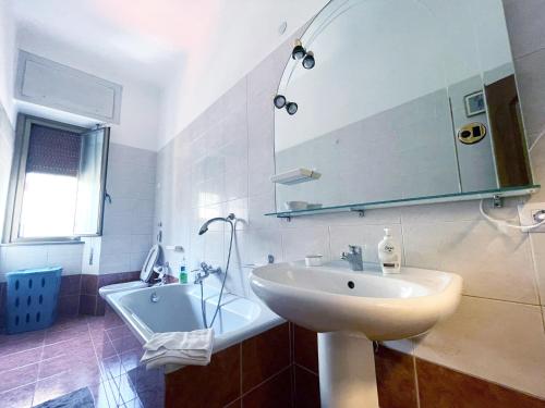 a bathroom with a sink and a mirror and a tub at Hostel Corner 32 in Milan