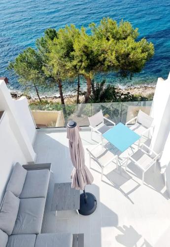 a group of white chairs and a table and the ocean at Casa Paraiso Acantilado1 in El Campello