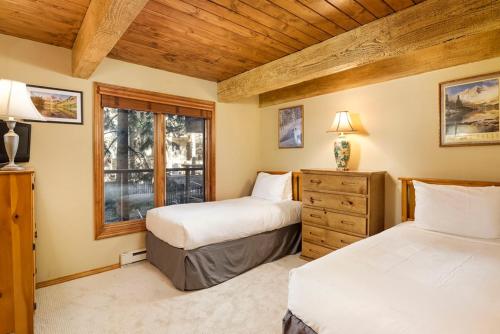 um quarto com 2 camas e uma janela em Chateau Eau Claire Unit 17, Serene Condo Overlooking the River with Many Upgrades em Aspen