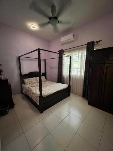 a bedroom with a bed and a ceiling fan at Homestay Dferry Jerantut Fully Aircond in Jerantut