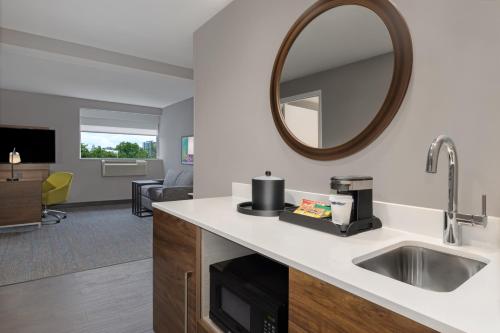 La salle de bains est pourvue d'un lavabo et d'un miroir. dans l'établissement Hampton Inn & Suites by Hilton Toronto Downtown, à Toronto