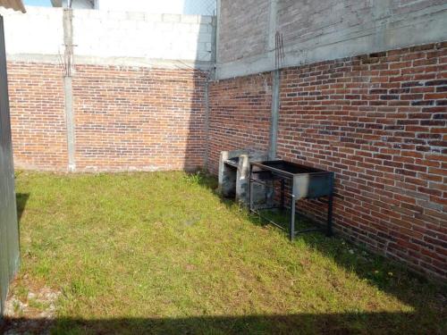 a brick wall with a trash can in a yard at CASA ACOGEDORA in Chignahuapan