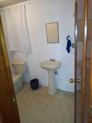 a bathroom with a sink and a toilet and a mirror at CASA ACOGEDORA in Chignahuapan
