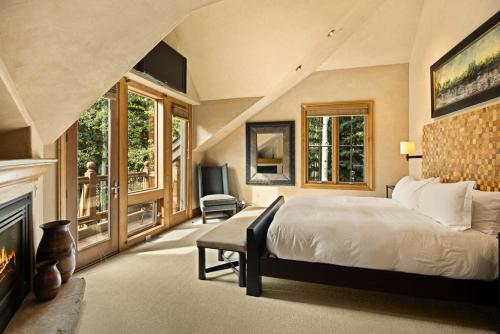 a bedroom with a large bed and a fireplace at Owl Creek 20, Luxury family home with private balcony, deck, hot tub, and patio - near lifts! in Snowmass Village