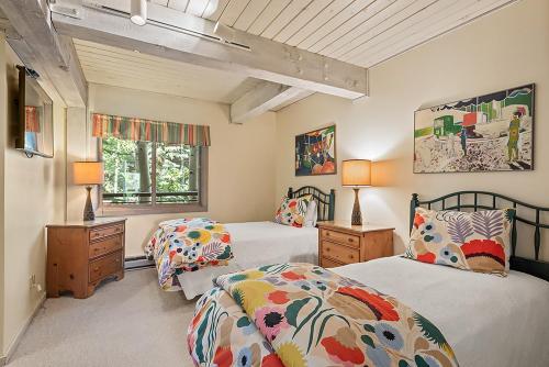 a bedroom with two beds and two lamps and a window at Enclave 205, Snowmass Ski-In/Ski-Out Condo w/Shared Pool/Hot Tub/Gym/WiFi in Snowmass Village
