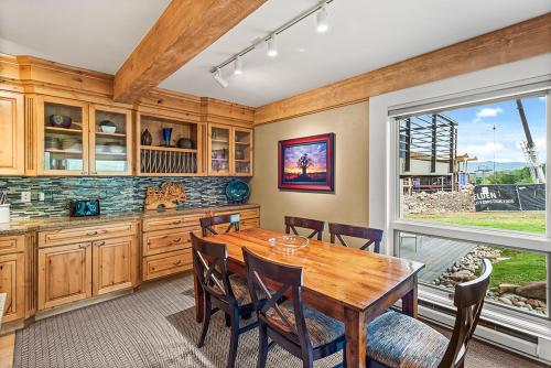 a kitchen with a wooden table and a large window at Enclave 102, Snowmass Ski-In/Ski-Out Condo w/Shared Pool/Hot Tub in Snowmass Village