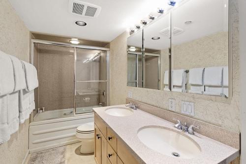 a bathroom with a sink and a toilet and a mirror at Chateau Eau Claire Unit 1, Stylish Condo Overlooking the River, Walking Distance to Downtown in Aspen
