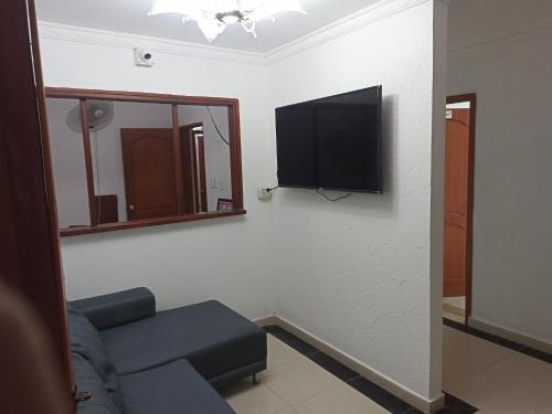 sala de estar con sofá y TV de pantalla plana en HOTEL VIP COMFORT, en Santa Marta