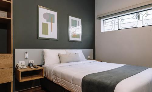 a bedroom with a large white bed and a window at TARATA BOUTIQUE HOTEL in Lima