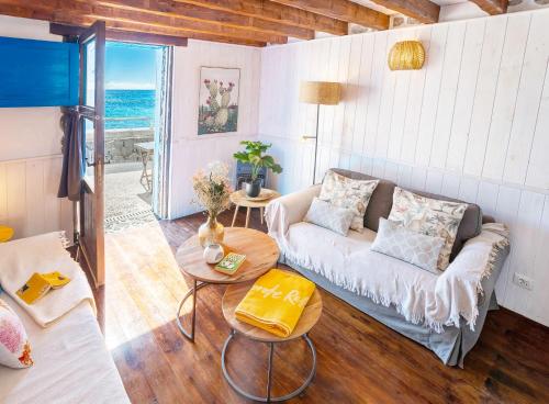 a living room with a couch and a table at Eco Fisherman's Seafront Cottage in Arrieta