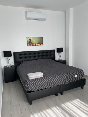 a bedroom with a black bed in a room at Luxe appartementen Paramaribo Noord in Paramaribo