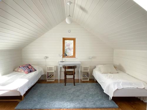 a room with two beds and a table in a attic at The Green House in Stockholm