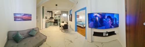 Full apartment near Kato Patissia في أثينا: غرفة معيشة مع أريكة وتلفزيون على الحائط