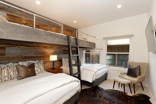 una camera con due letti e una grande parete in legno di Durant Unit D5, Luxury Condo with Beautiful Furnishings, Great Views, and Central A/C ad Aspen