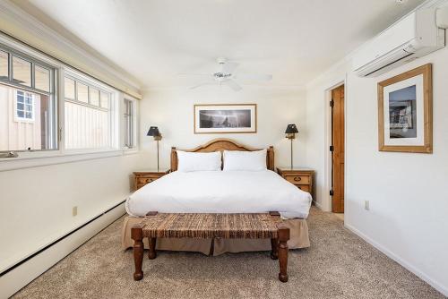 a bedroom with a large white bed and a window at Fasching Haus Unit 8, Deluxe Condo w/ A/C, Private Deck, 2 Blocks to Downtown in Aspen