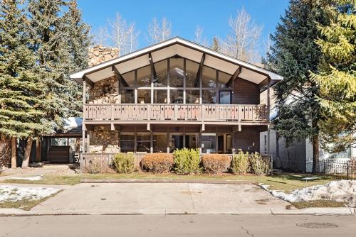 a large wooden house with a balcony on a street at 118 E. Bleeker St. Upper level, Condo in Duplex with Private Deck in Aspen
