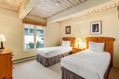 a bedroom with two beds and a window at Chateau Roaring Fork Unit 37, Spacious Condo, Close to Downtown. Pool, Hot Tub, Fitness Center in Aspen