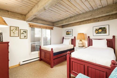 a bedroom with two beds and a window at Chateau Eau Claire Unit 8, Riverfront Condo, Walking Distance to Town in Aspen