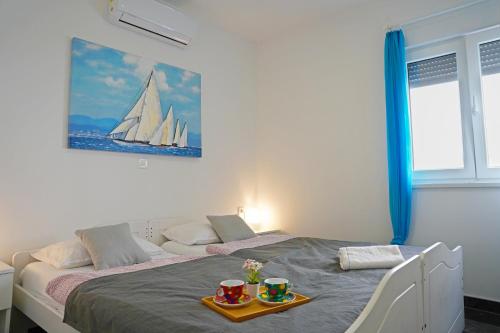 a bedroom with a bed with two cups on it at Sobol Apartments 'Navis' with private jacuzzi in Crikvenica