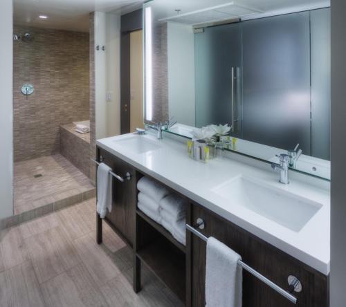 ein Bad mit einem Waschbecken, einem Spiegel und einer Dusche in der Unterkunft Hotel Eastlund - Best Western Premier Collection in Portland