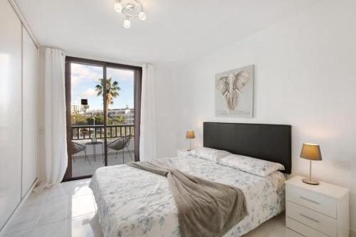 Habitación blanca con cama y balcón. en Parque Santiago 2 Luxury Apartment en Playa de las Americas