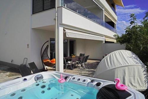 a hot tub with two pink flamingos in a backyard at Sobol Apartments 'Navis' with private jacuzzi in Crikvenica