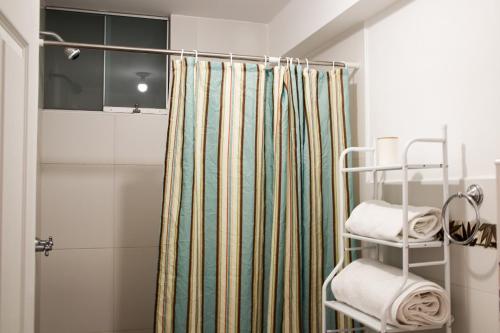 ein Bad mit einem Duschvorhang und einigen Handtüchern in der Unterkunft Aura Apartamento Cusco in Cusco