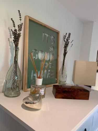 three vases sitting on a table with a picture and a lamp at Sauro 43 in Pisa