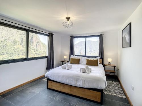 - une chambre avec un grand lit et de grandes fenêtres dans l'établissement Mystic Mountain by Atlantic Holiday, à São Vicente