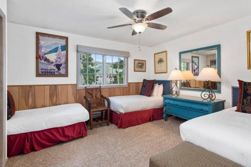 a bedroom with two beds and a ceiling fan at Alpenblick 1, Three Level Townhouse with Fireplace, Private Balcony, and Great Location in Aspen
