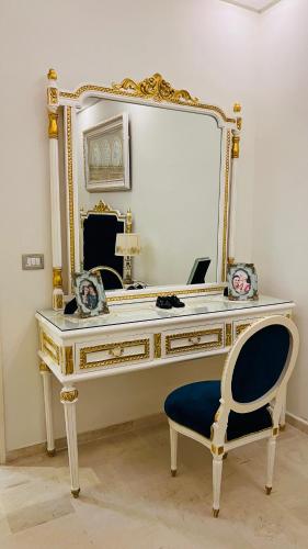 a dressing table with a mirror and a blue chair at Maison Fathallah in Mahdia