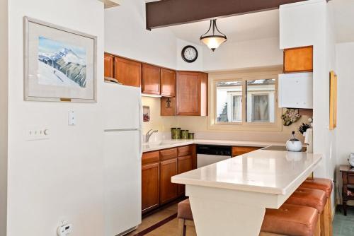 uma cozinha com um frigorífico branco e armários de madeira em 118 E. Bleeker Street Home, Large, Two-Level Home/Duplex with Private Deck & On-Site Parking em Aspen