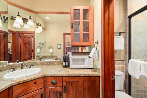 a bathroom with a sink and a microwave on a counter at Independence Square 308, Top Floor Hotel Room with Ideal Downtown Location in Aspen