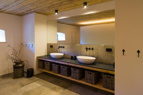 a bathroom with two sinks and a mirror at Historisches Pfarrhaus Nähe Schloss Neuschwanstein in Burggen