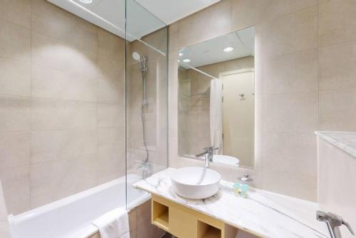 a bathroom with a sink and a shower at Paramount, Midtown - Locations in Dubai