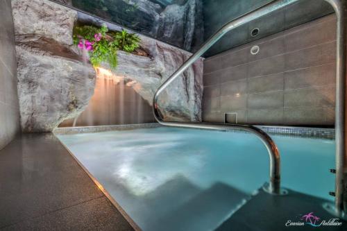 a hot tub in a bathroom with a rock wall at Evasion Antillaise in Marseille