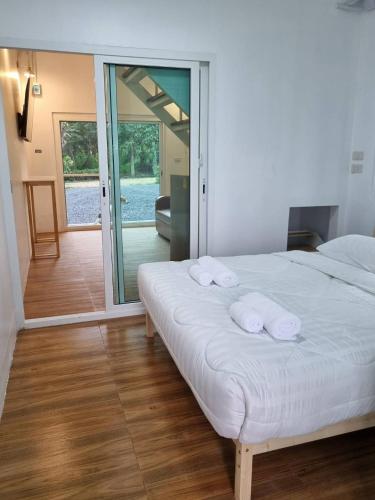 a bedroom with two white towels on a bed at Wind in the Wild Khao Yai in Nakhon Ratchasima