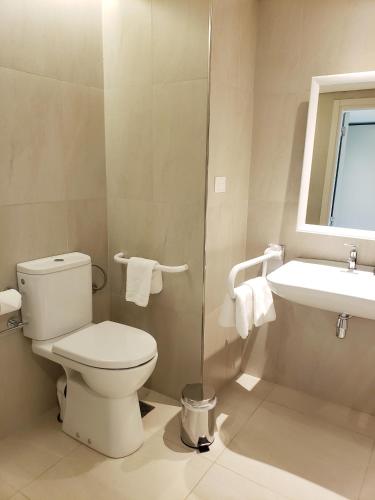 a bathroom with a toilet and a sink at Hilton Garden Inn Neuquen in Neuquén